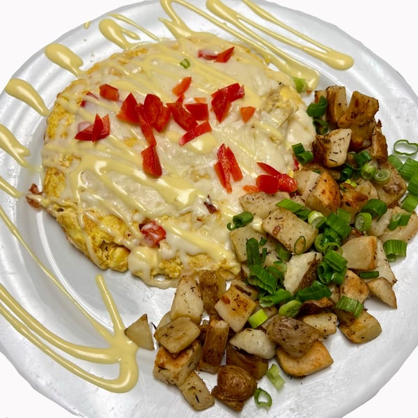 Sweet Berry Cafe's omelet with melted cheese, red peppers, and a side of home fries with green onions.